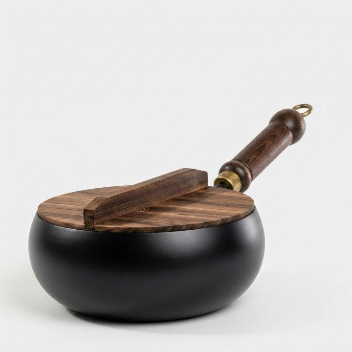 Gusseisenpfanne mit Holzdeckel und Griff