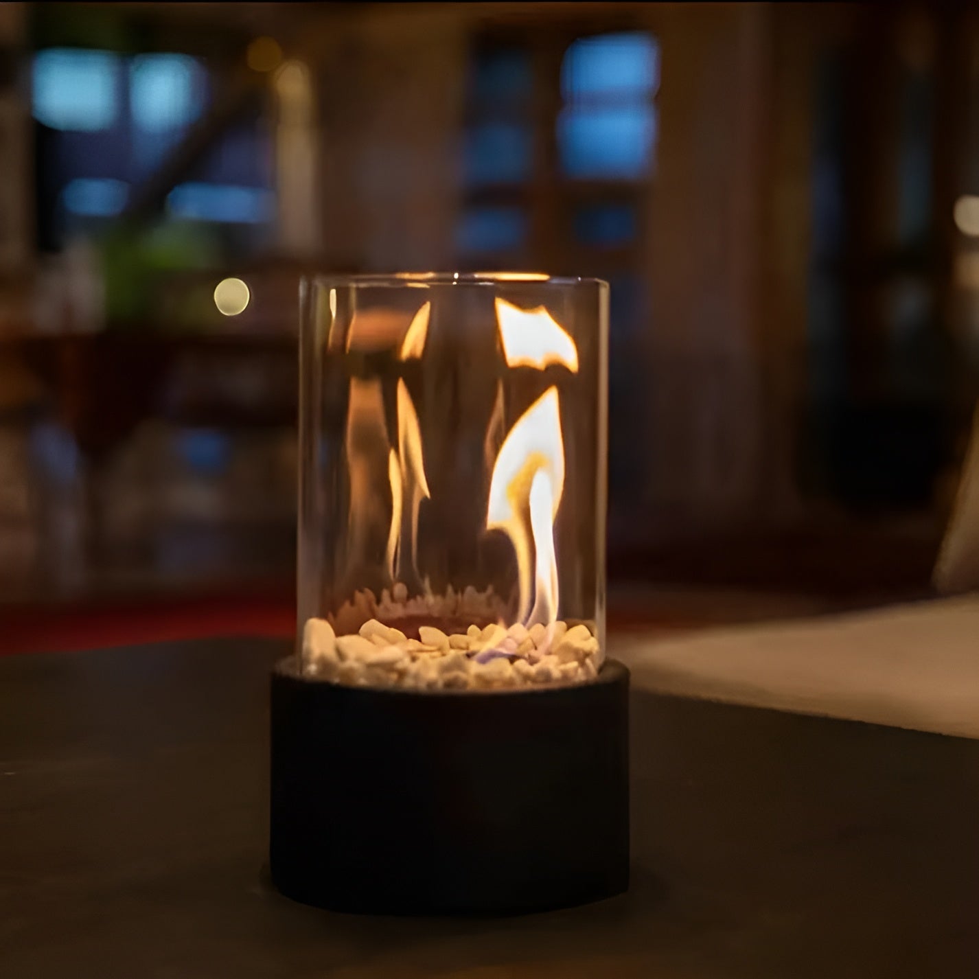 Table fireplace with glass cylinder and metal base