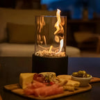 Table fireplace with glass cylinder and metal base