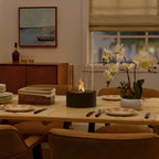Table fireplace with glass cylinder and metal base