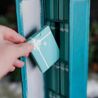 Book advent calendar with 25 mini books on a bookshelf, turquoise